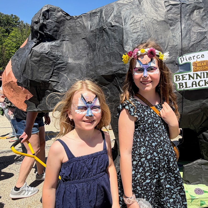 Students stand with the giant black bear puppet for the parade. 